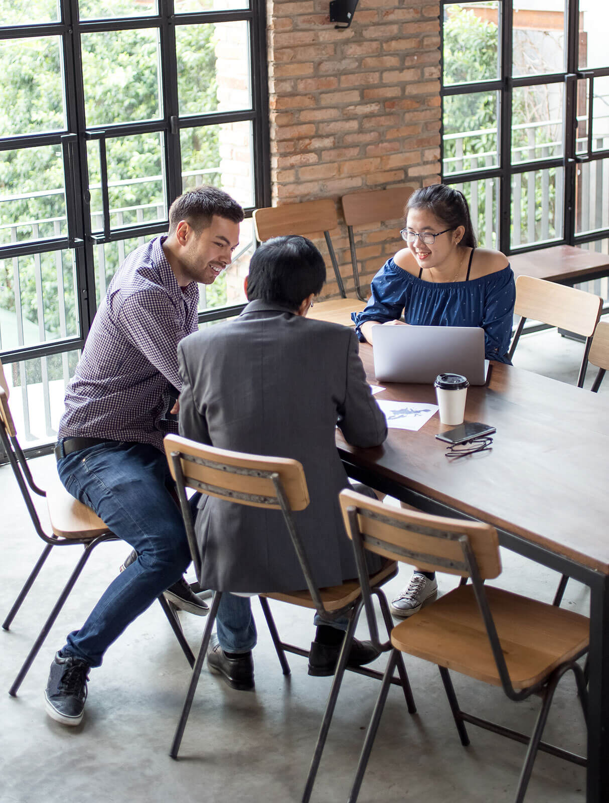 Three people having a conversation at a table.